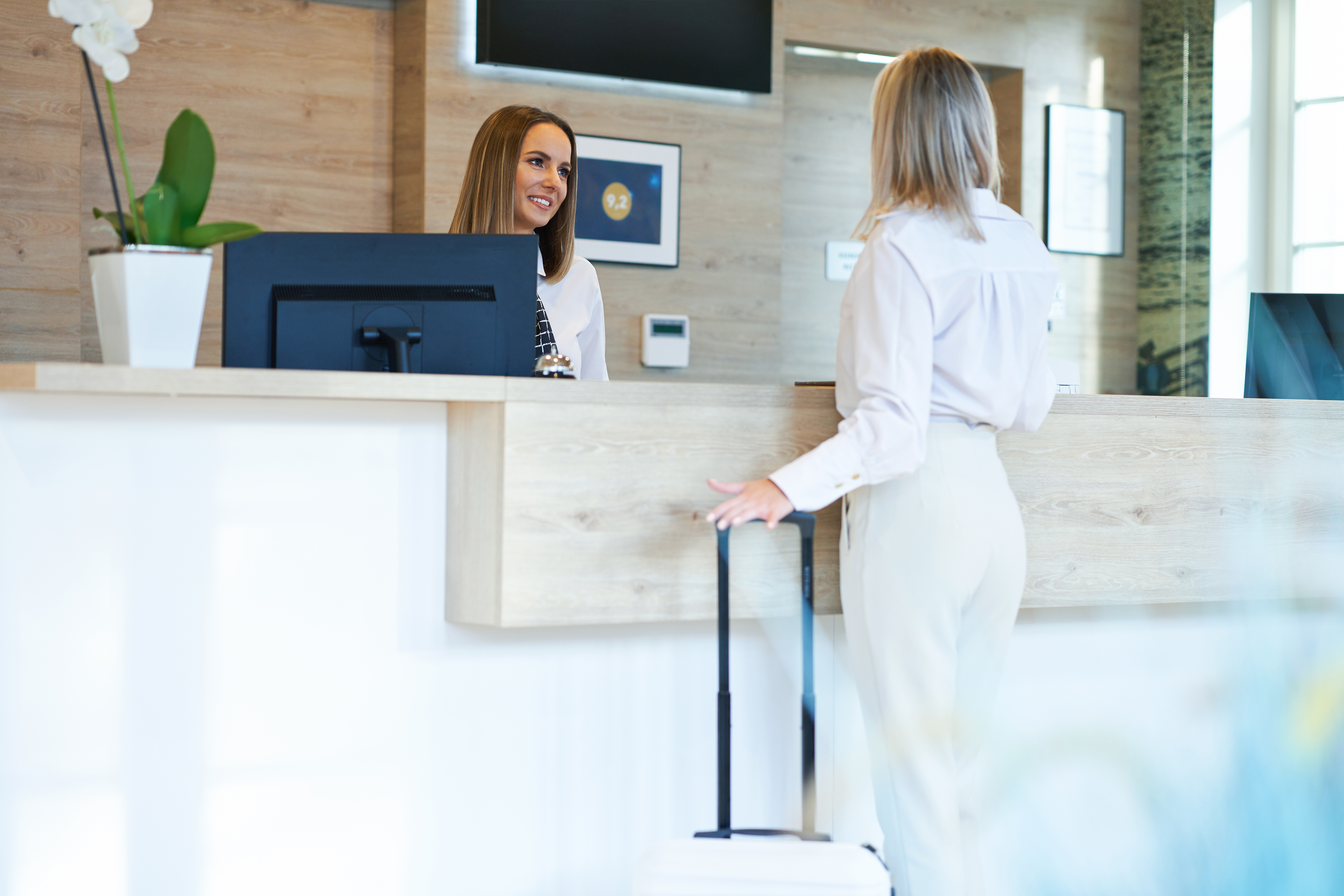 Recepcionista y mujer de negocios en recepción del hotel