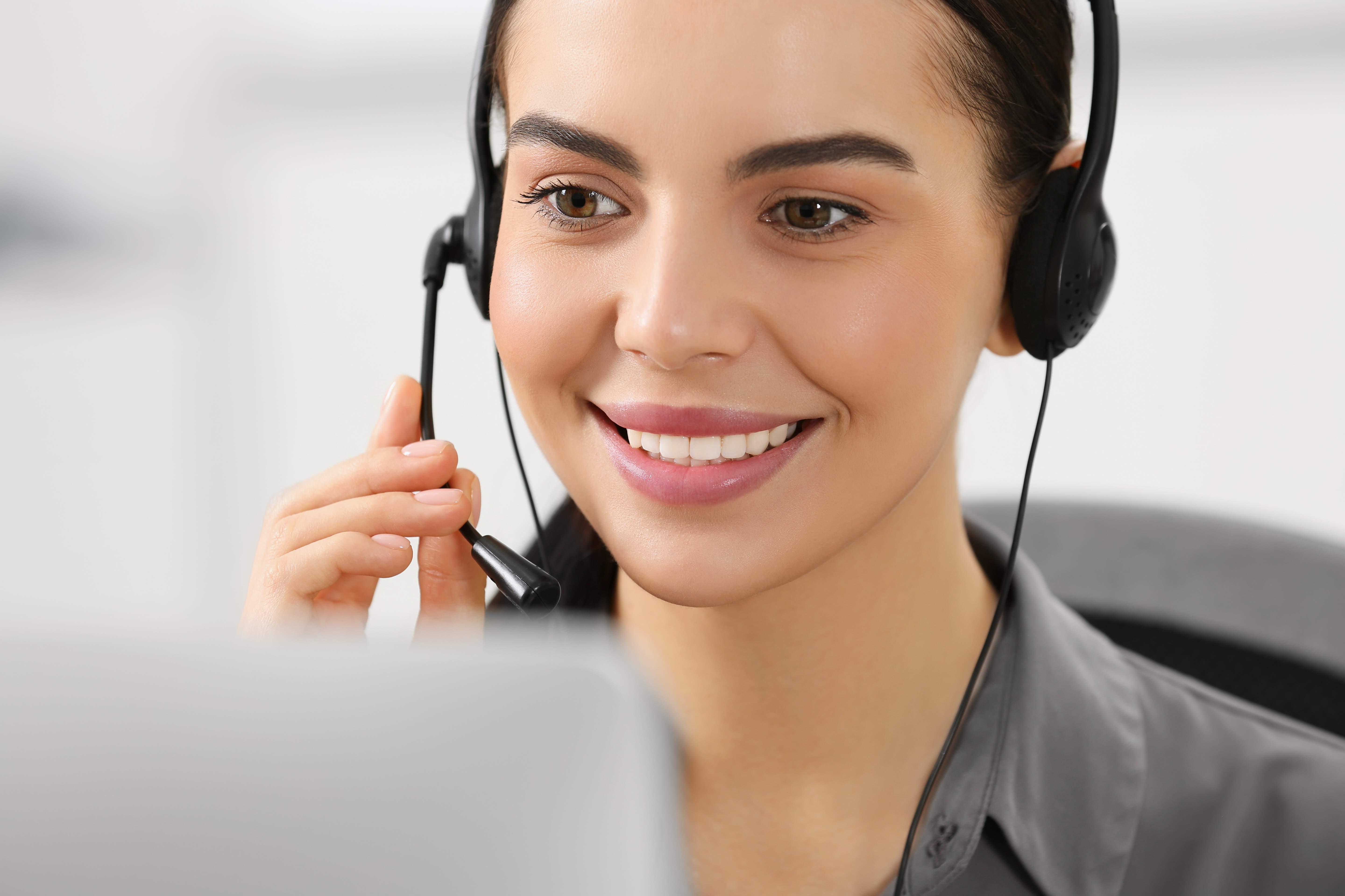 Operador de línea directa con auriculares trabajando en una computadora en la oficina